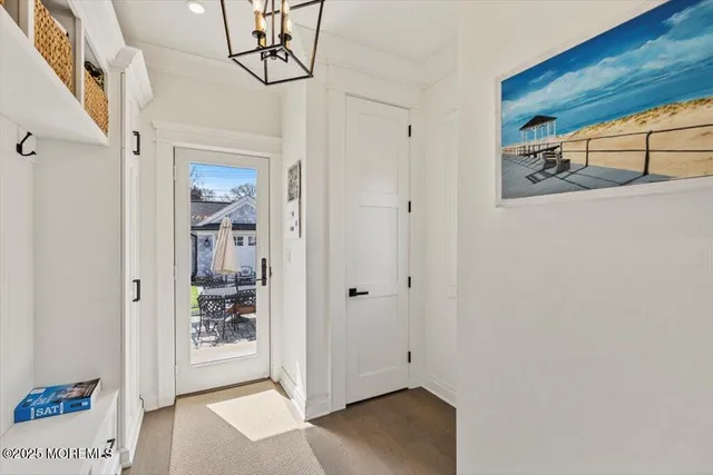 a view of a hallway with wooden floor and front door