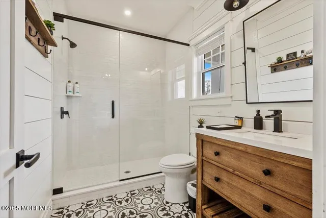 a bathroom with a granite countertop sink a toilet and shower