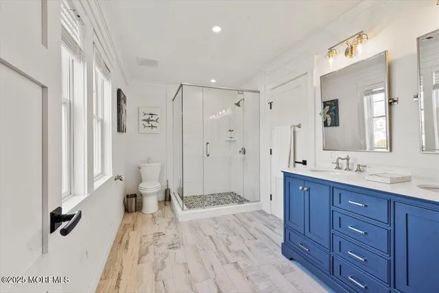 a spacious bathroom with a granite countertop sink a mirror a vanity and a shower