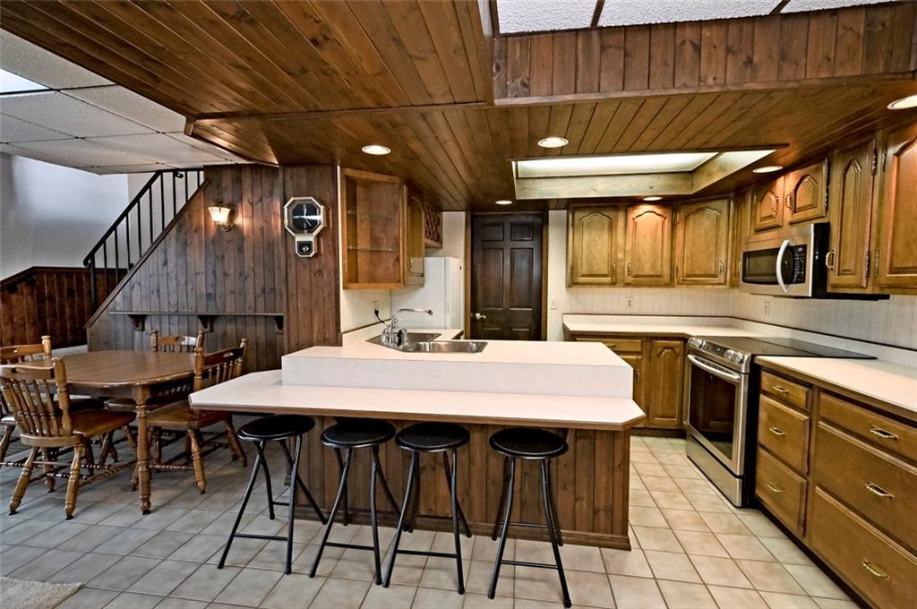 1050 Lagonda Road Washington, PA 15301 - Photo 19 of 25 a kitchen with stainless steel appliances granite countertop a sink a stove a refrigerator a dining table and chairs with wooden floor