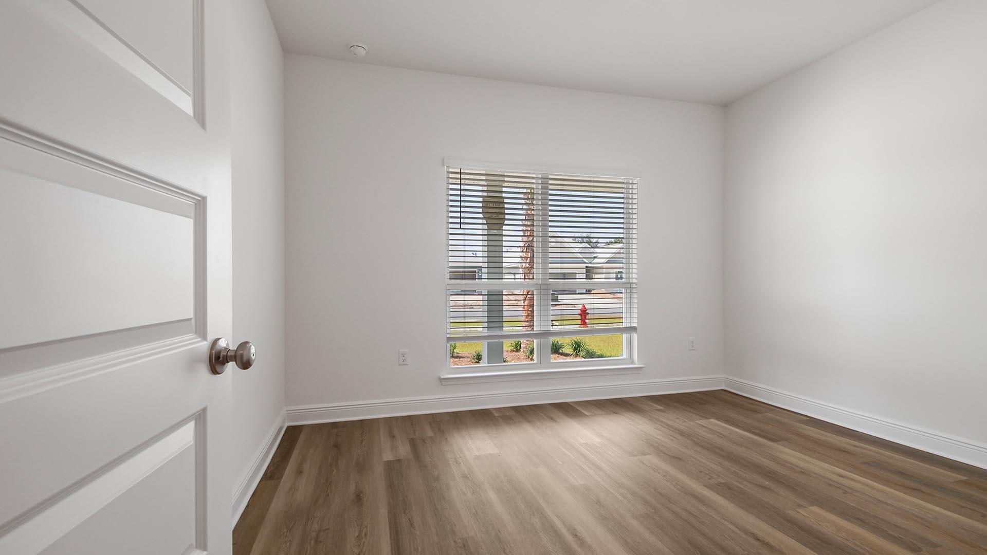 313 Holley Grv Lane Santa Rosa Beach, FL 32459 - Photo 27 of 34 an empty room with wooden floor and windows