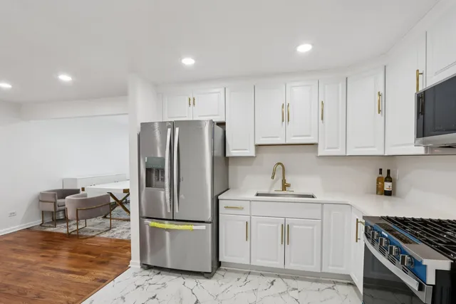 a kitchen with a refrigerator sink and cabinets