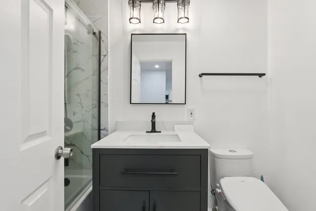 a bathroom with a sink toilet and mirror