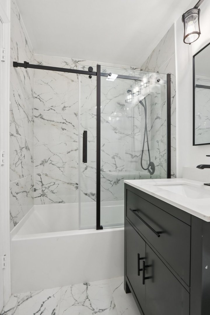 8916 Kenneth Drive, Unit 1E Des Plaines, IL 60016 - Photo 19 of 27 a bathroom with a bathtub and a sink