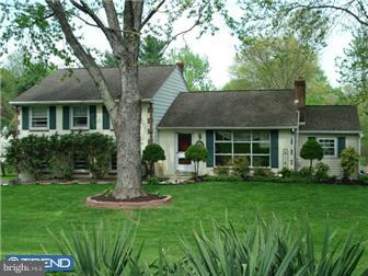 a front view of a house with a yard and green space
