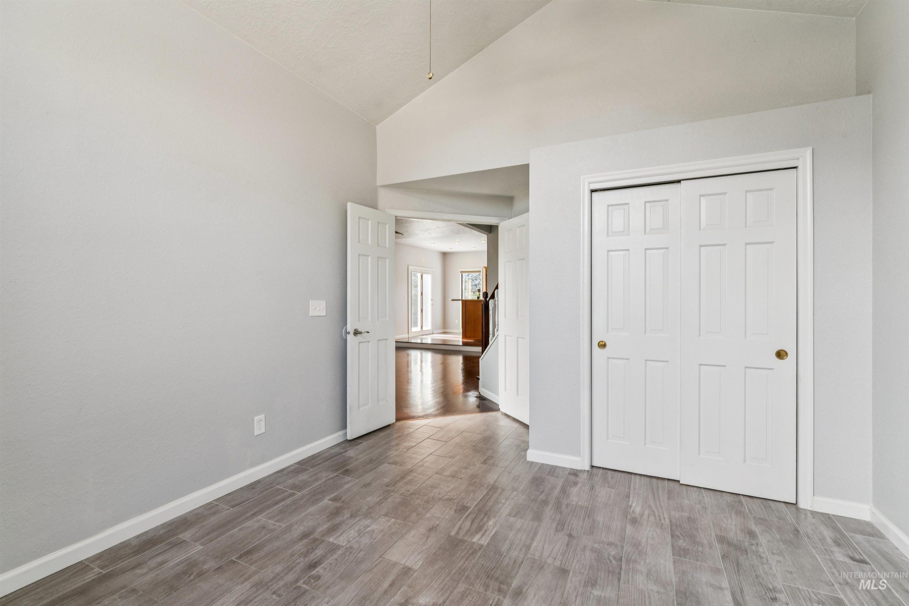 9831 West Ripley Street Boise, ID 83704 - Photo 16 of 47 Dining area featuring lustrous wood-finish flooring, a contemporary chandelier, multiple large windows, and direct access to an outdoor deck through double glass doors