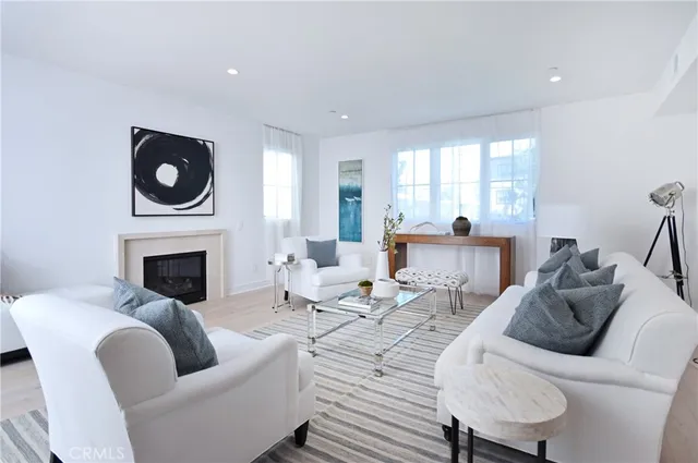 a living room with furniture a fireplace and a floor to ceiling window