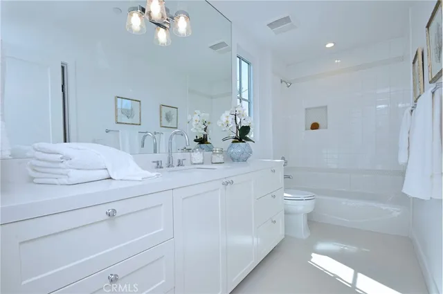 a bathroom with a toilet a sink a tub and mirror