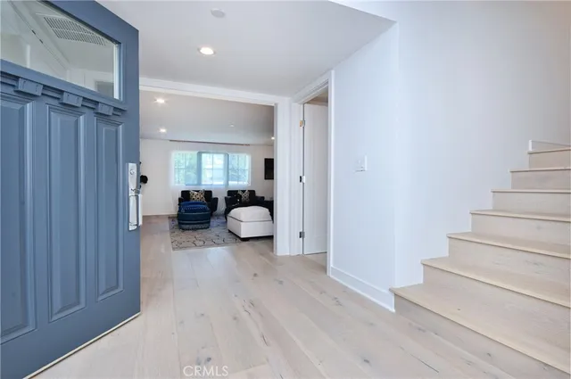a view of a hallway with wooden floor and furniture