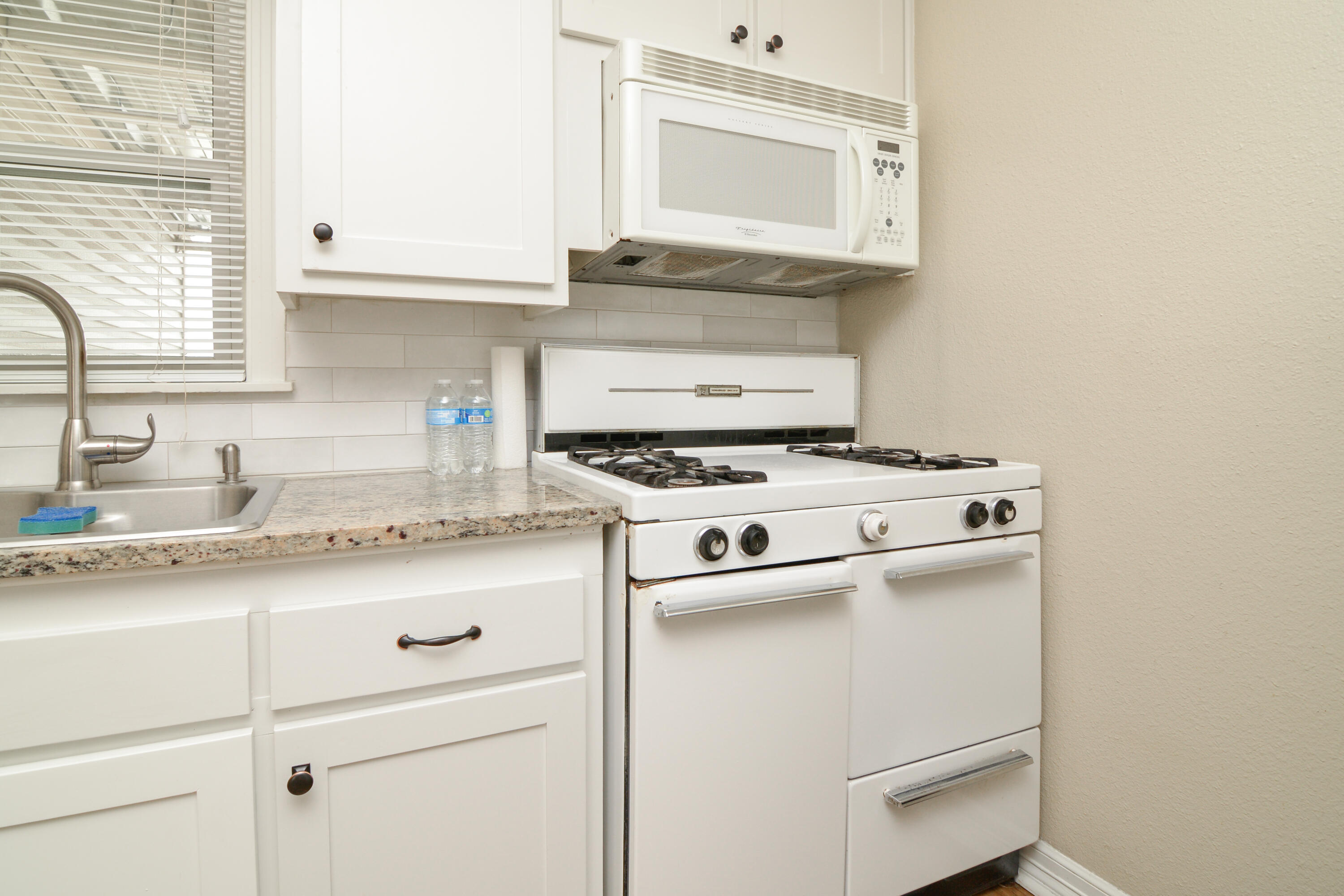 4907 41st Street Lubbock, TX 79414 - Photo 11 of 39 a kitchen with granite countertop cabinets stainless steel appliances and a sink