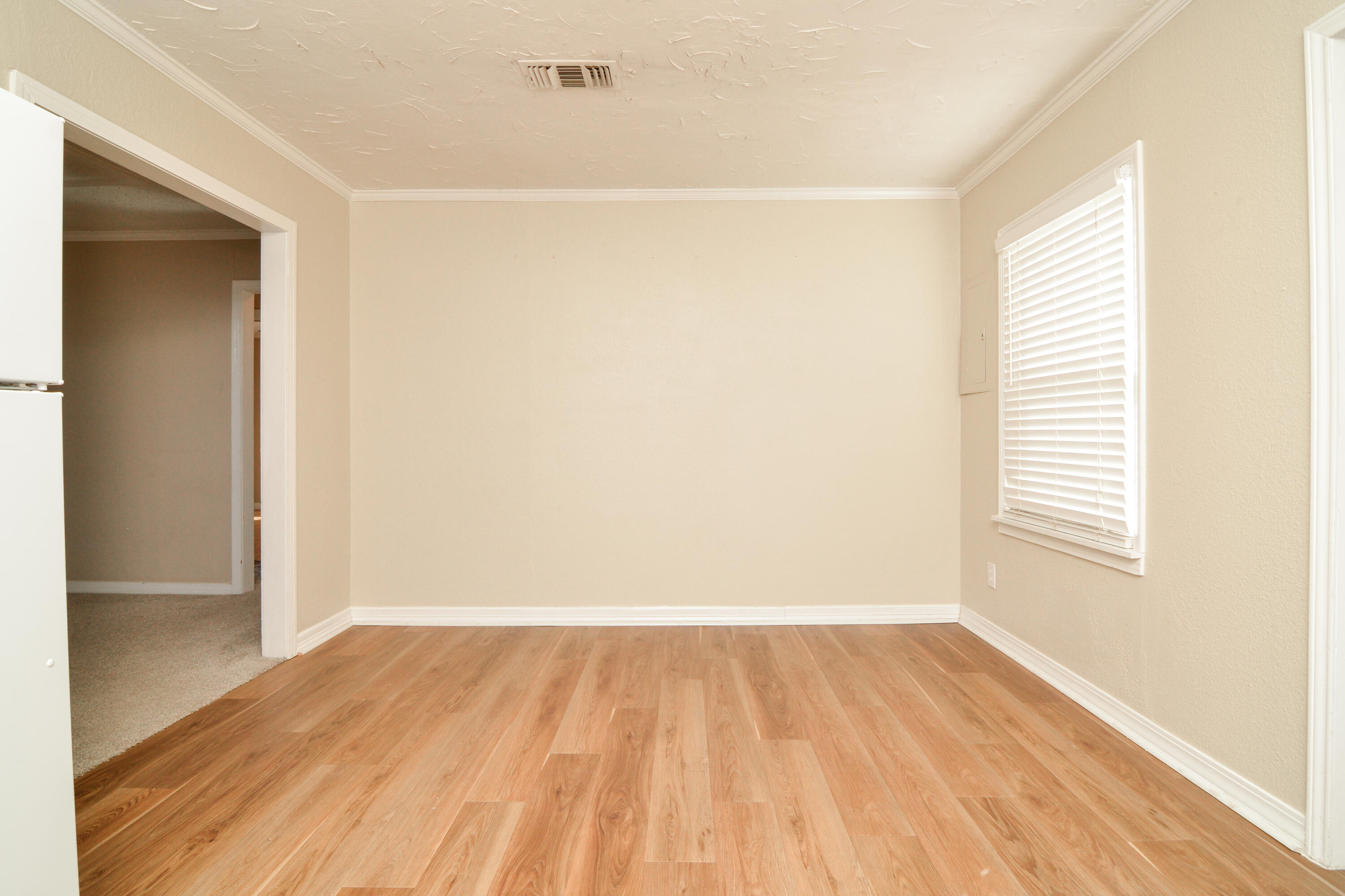4907 41st Street Lubbock, TX 79414 - Photo 12 of 39 an empty room with wooden floor and windows