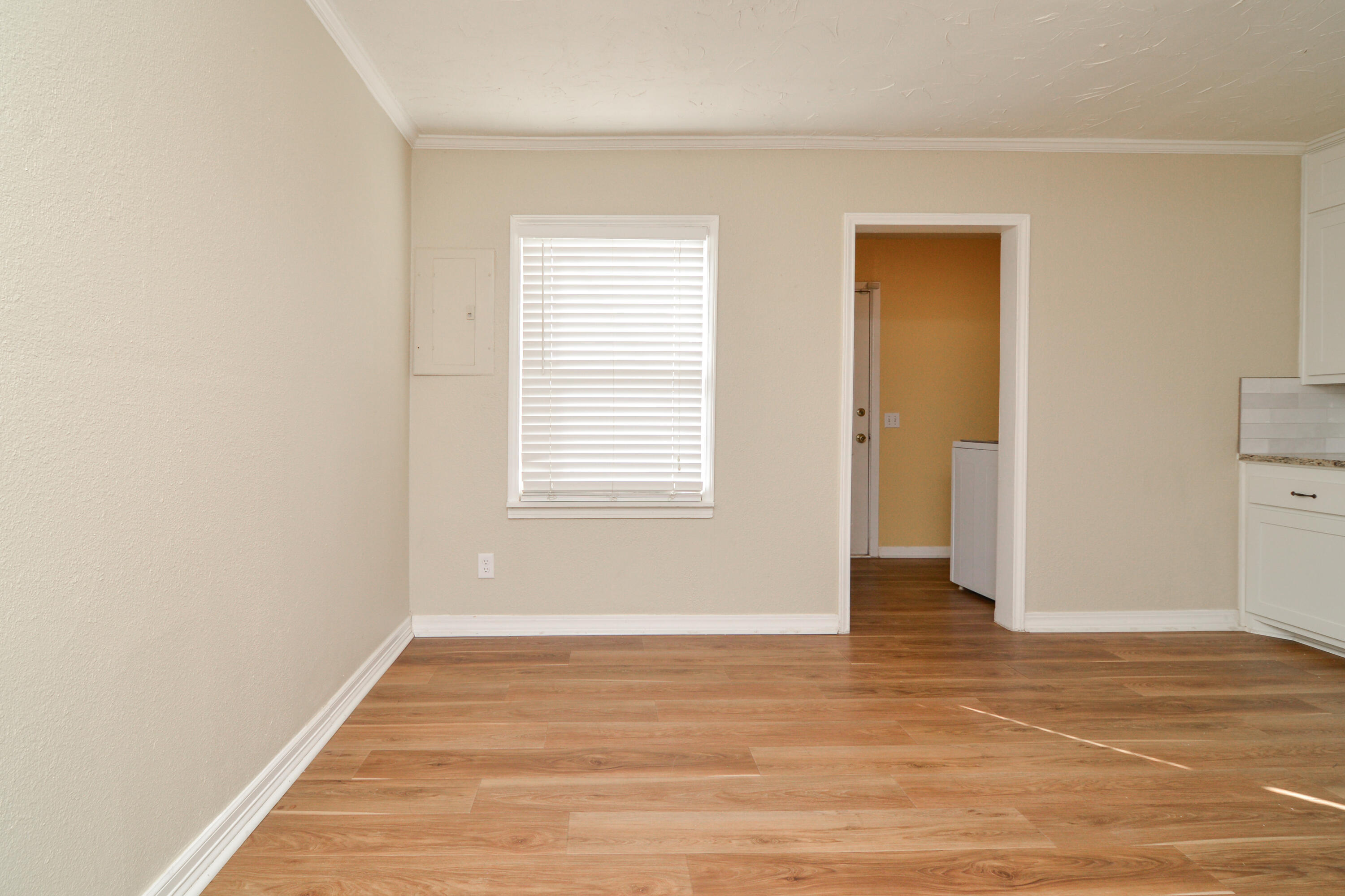 4907 41st Street Lubbock, TX 79414 - Photo 13 of 39 a view of an empty room with wooden floor and a window
