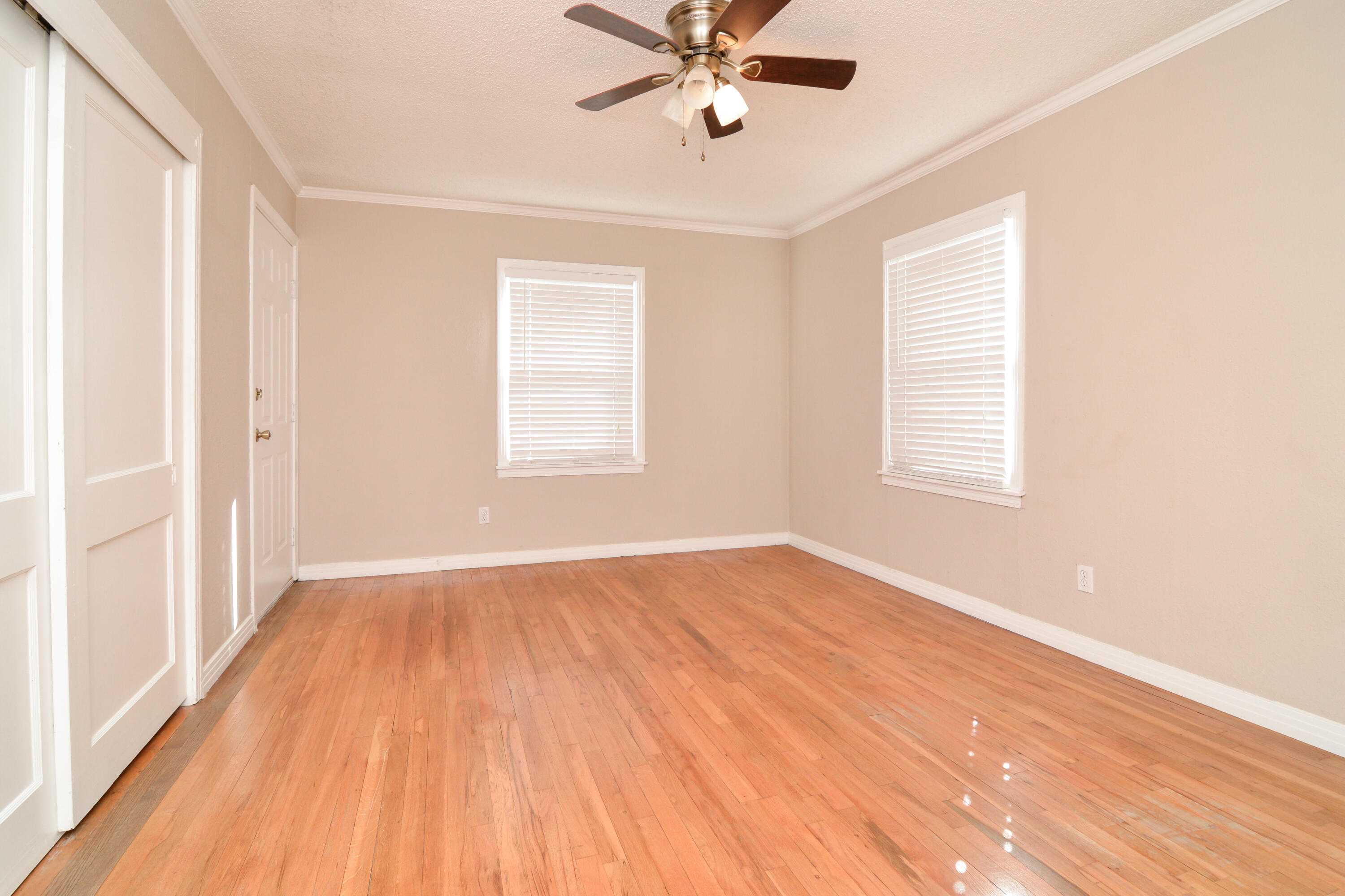 4907 41st Street Lubbock, TX 79414 - Photo 18 of 39 a view of an empty room with wooden floor and a window
