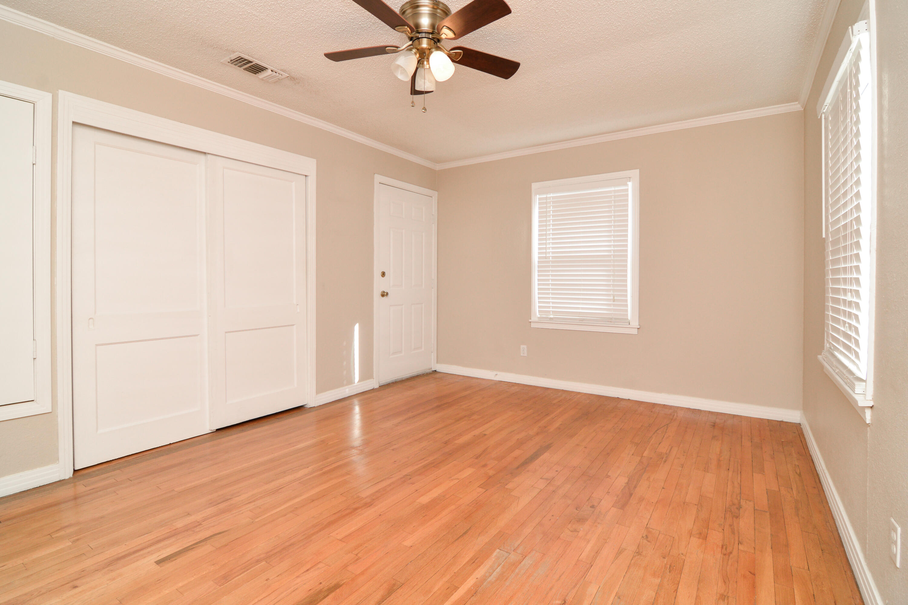 4907 41st Street Lubbock, TX 79414 - Photo 19 of 39 a view of an empty room with wooden floor and a window