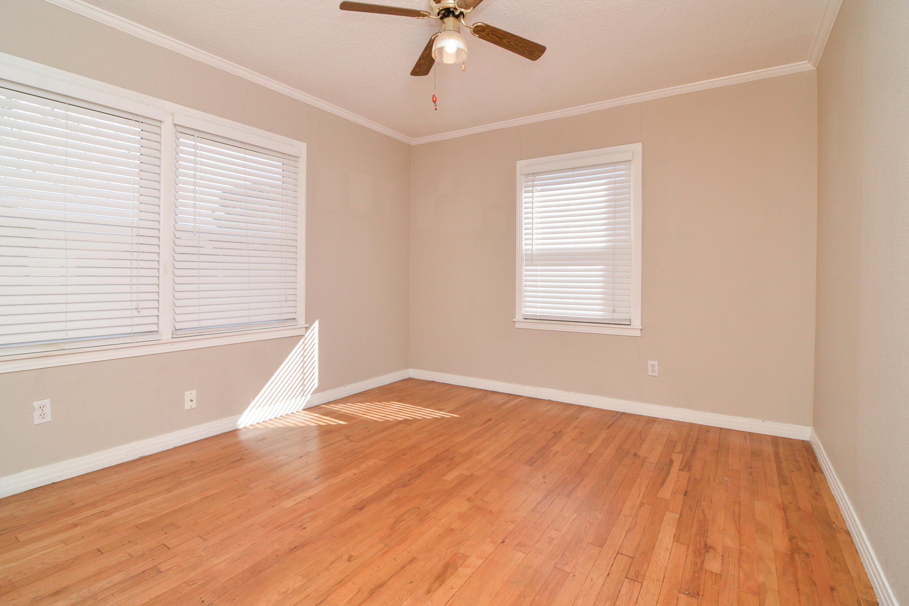 4907 41st Street Lubbock, TX 79414 - Photo 23 of 39 a view of an empty room with wooden floor and a window