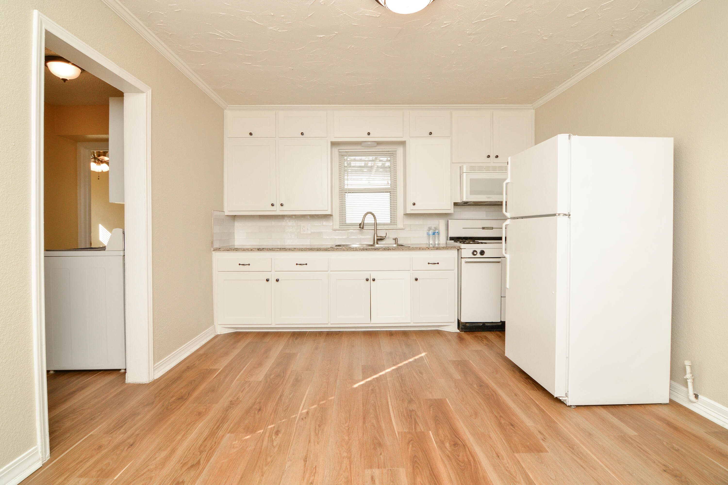 4907 41st Street Lubbock, TX 79414 - Photo 9 of 39 a kitchen with a sink a refrigerator and a window