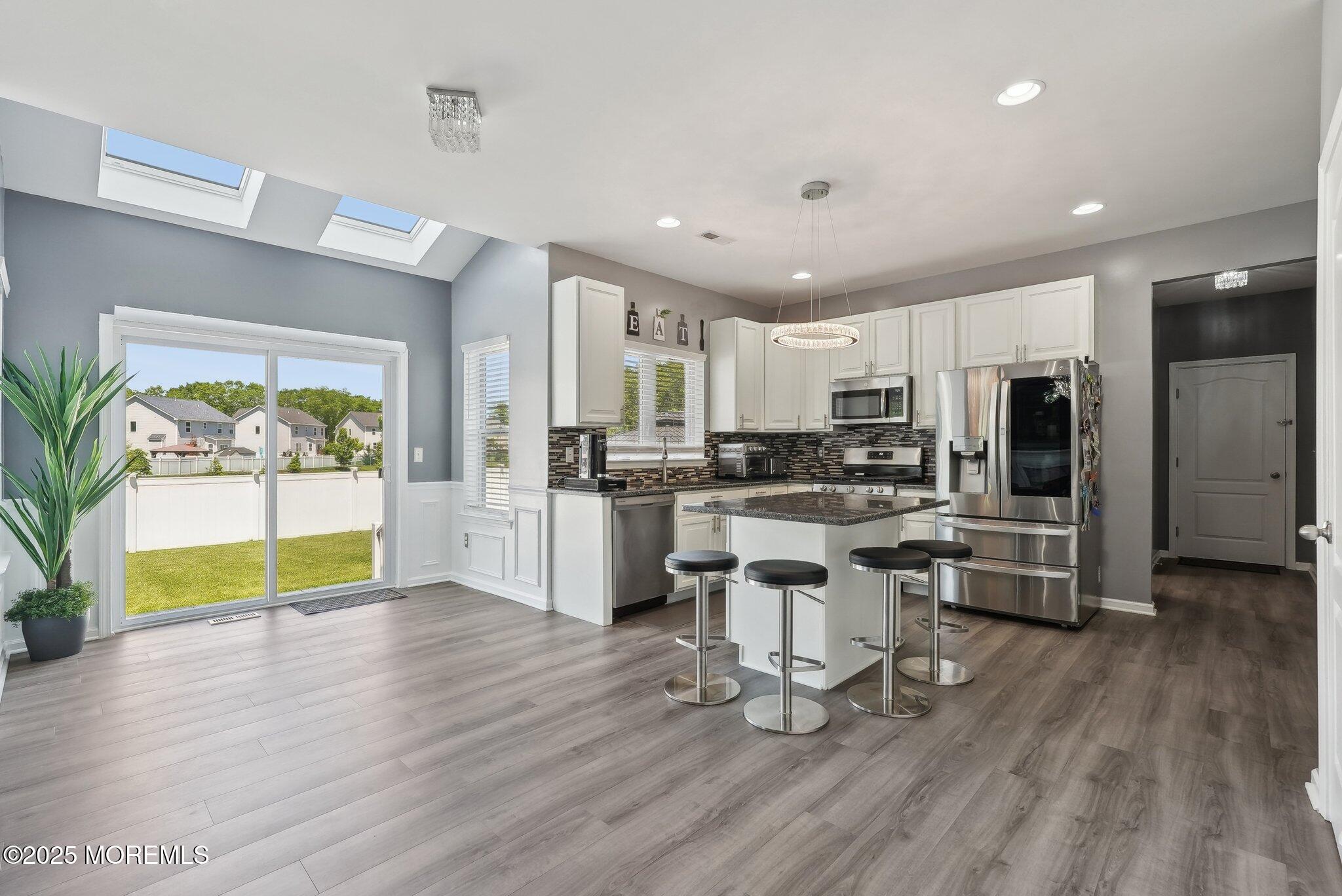 4 Bridle Path Bayville, NJ 08721 - Photo 14 of 44 a kitchen with stainless steel appliances a stove a sink a refrigerator and a dining table with wooden floor
