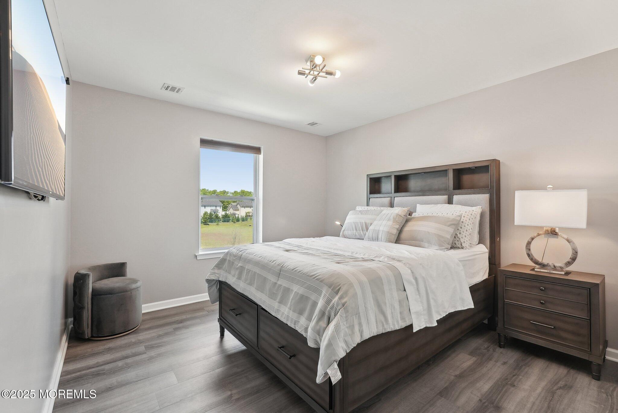 4 Bridle Path Bayville, NJ 08721 - Photo 31 of 44 a bedroom with a bed and a chandelier