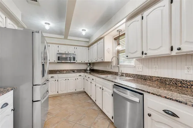 a kitchen with granite countertop cabinets stainless steel appliances a sink and a counter top space