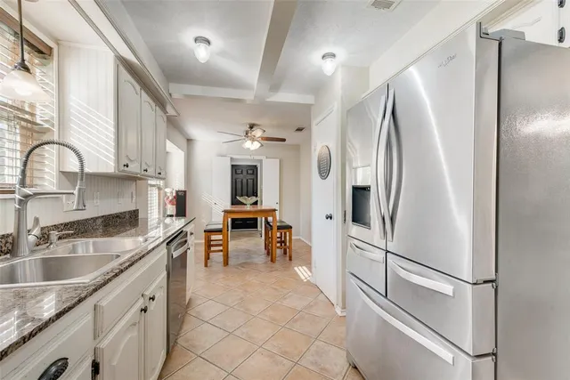 a kitchen with stainless steel appliances granite countertop a refrigerator and a sink