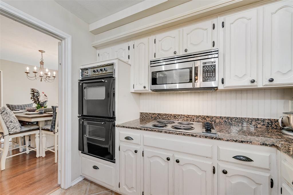 1923 Baylor Drive Richardson, TX 75081 - Photo 20 of 39 a kitchen with granite countertop white cabinets and white appliances