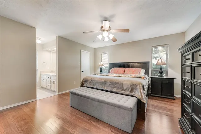 a bedroom with a large bed a chandelier and dresser
