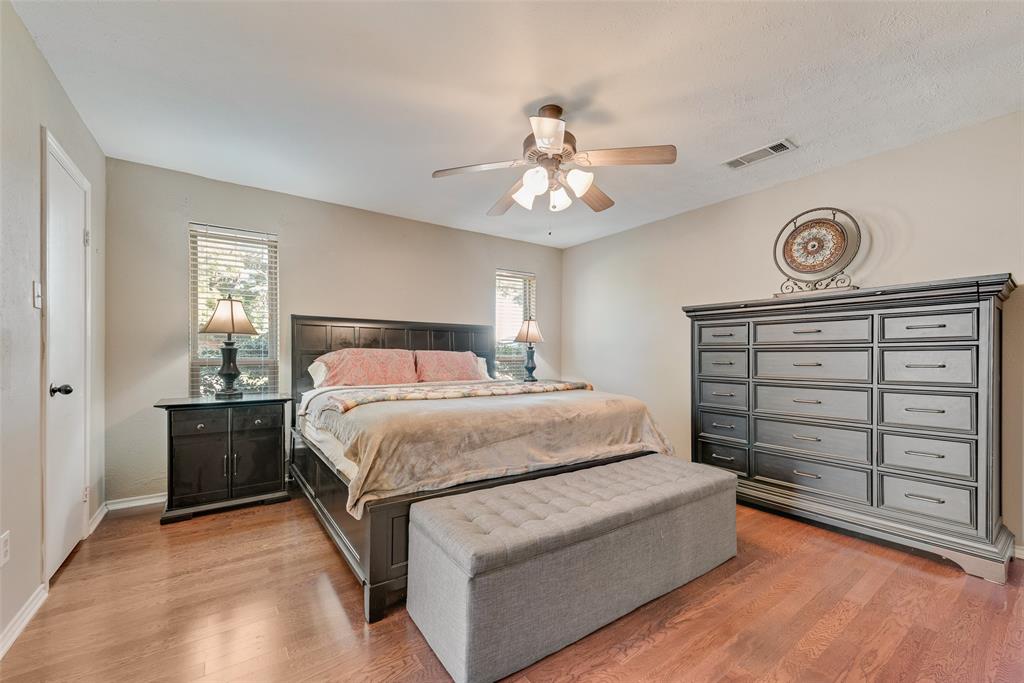 1923 Baylor Drive Richardson, TX 75081 - Photo 27 of 39 a spacious bedroom with a bed and a chandelier