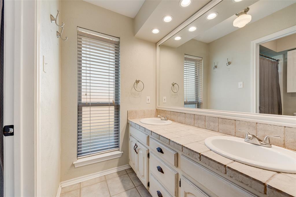 1923 Baylor Drive Richardson, TX 75081 - Photo 29 of 39 a bathroom with a granite countertop sink and a mirror