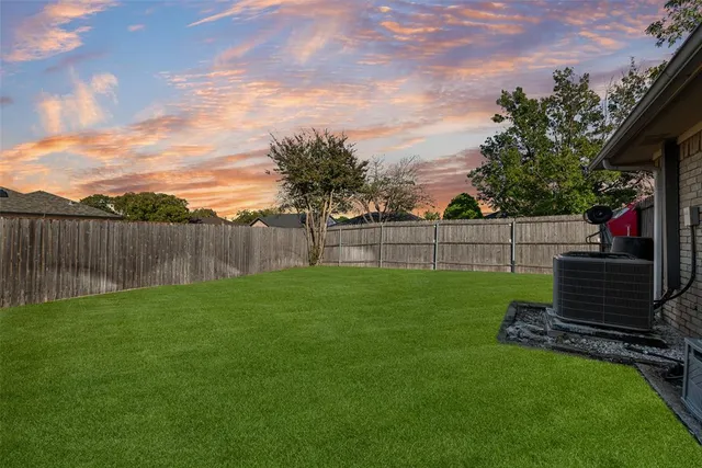 a view of a backyard with wooden fence