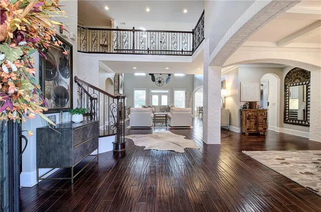 a view of a dining room and livingroom with furniture wooden floor a chandelier