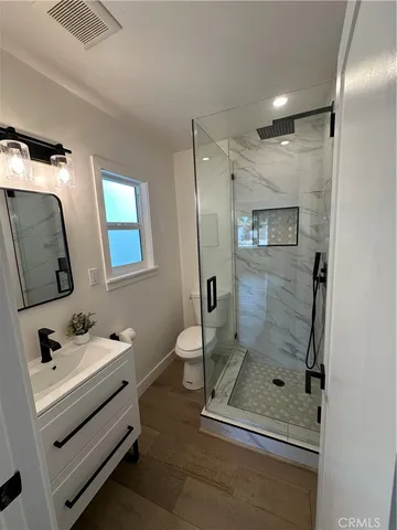 a bathroom with a shower sink and mirror