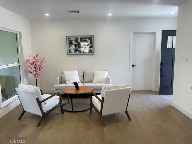 a living room with furniture a rug and a painting