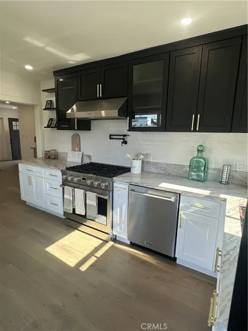 a kitchen with stainless steel appliances kitchen island granite countertop a sink stove and cabinets