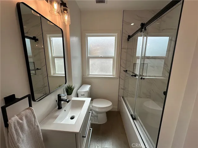 a bathroom with a sink mirror toilet and shower