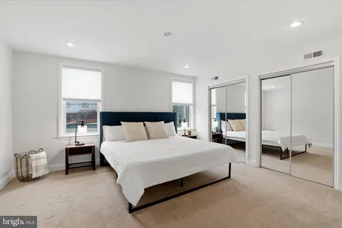 a spacious bedroom with a bed couch and a window