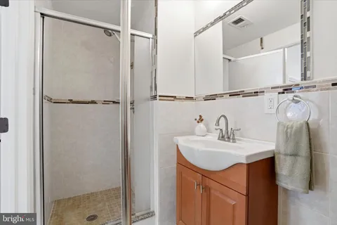 a bathroom with a sink vanity and shower