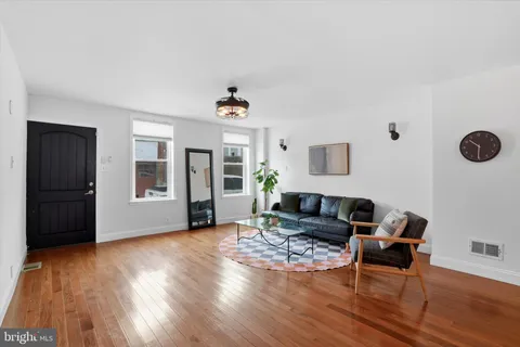 a living room with furniture and wooden floor