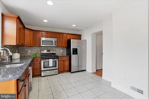 a kitchen with stainless steel appliances granite countertop a stove microwave and sink