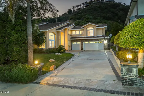 a front view of a house with a yard and potted plants
