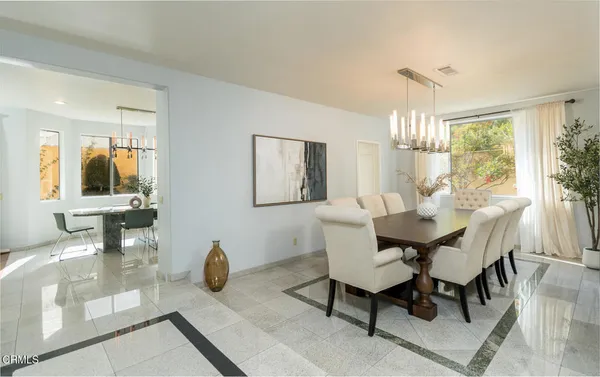 a kitchen with a dining table chairs refrigerator and cabinets