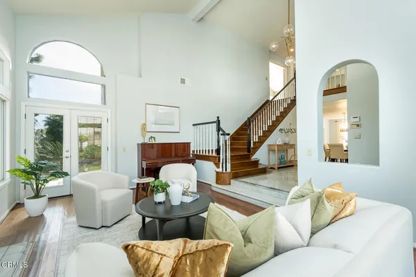 a living room with furniture a fireplace a potted plant and a large window