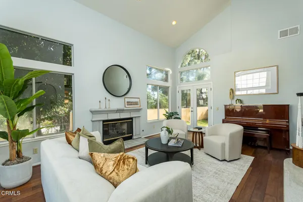 a living room with furniture a fireplace and a large window