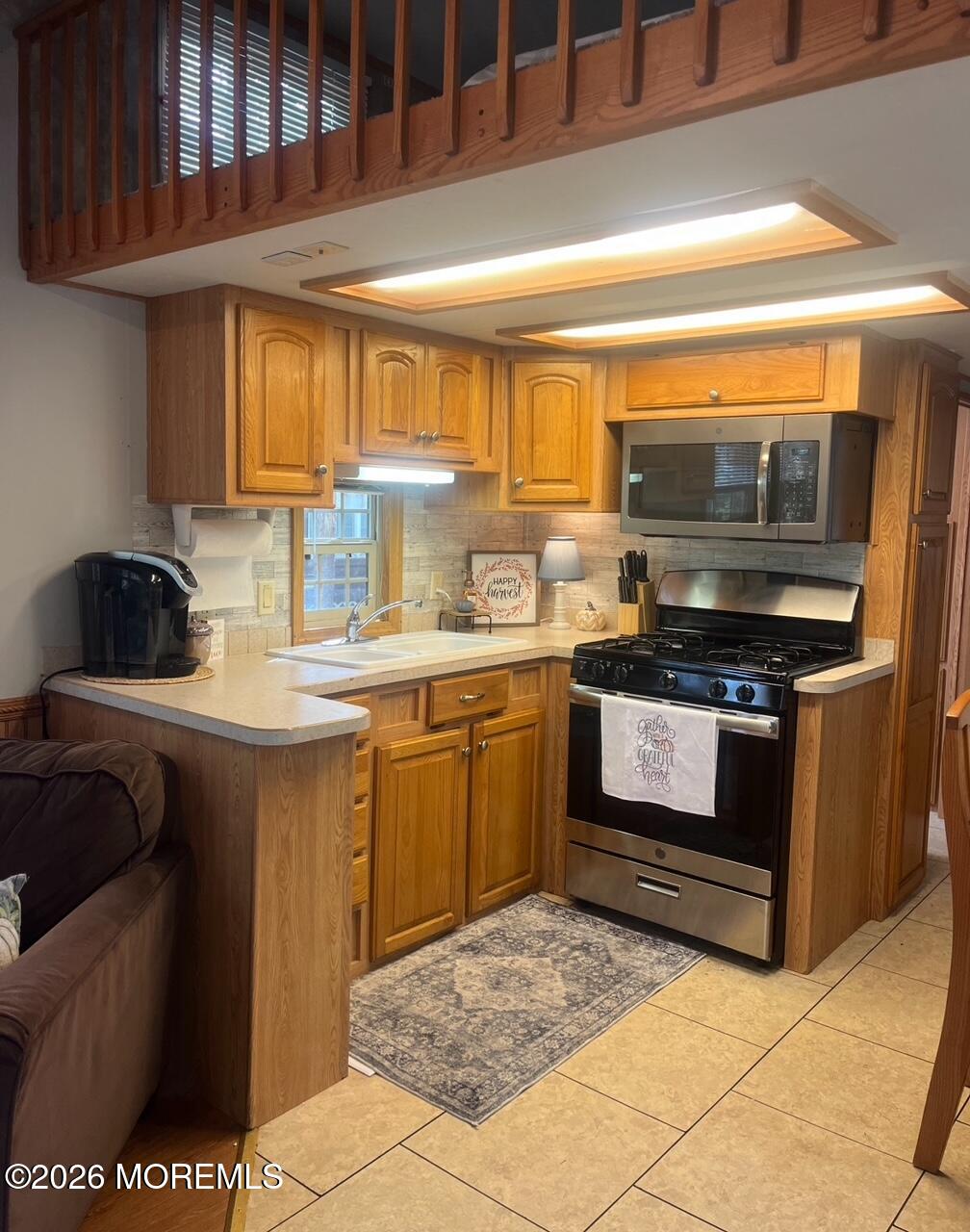 724 Monmouth Road, Unit 34 Cream Ridge, NJ 08514 - Photo 3 of 18 a kitchen with a stove a sink and a microwave