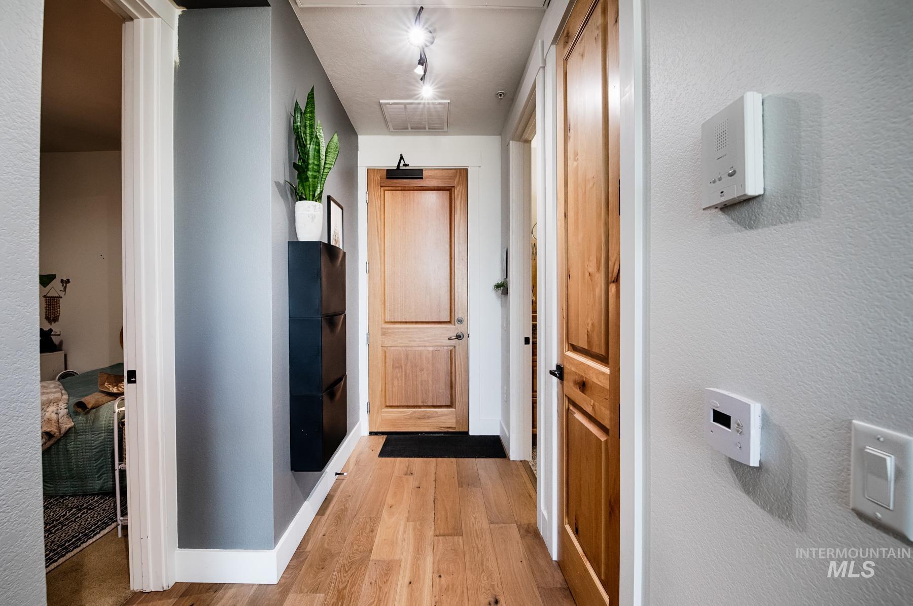 851 West Front Street, Unit 1004 Boise, ID 83702 - Photo 1 of 27 Hallway featuring light wood-style flooring and a textured wall