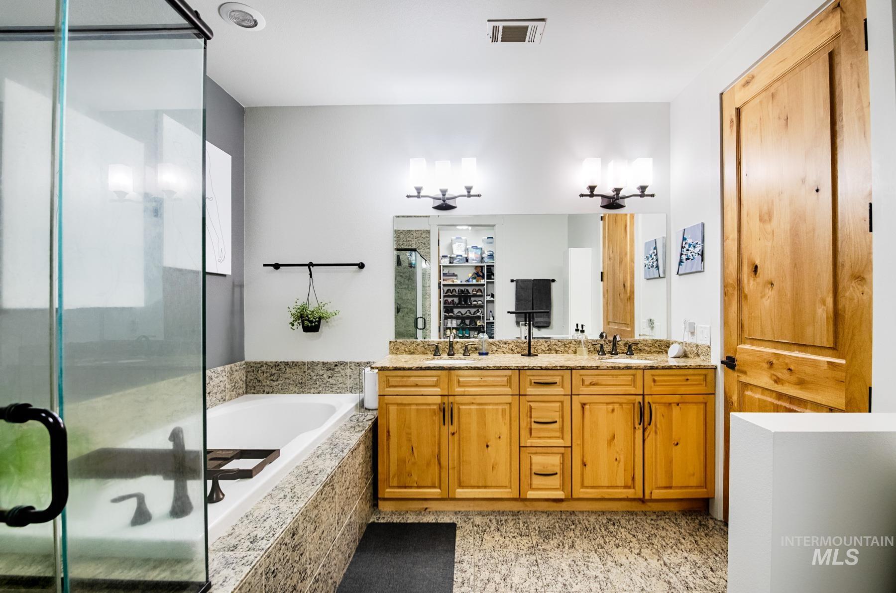 851 West Front Street, Unit 1004 Boise, ID 83702 - Photo 14 of 27 Full bathroom featuring a bath, double vanity, and a shower stall