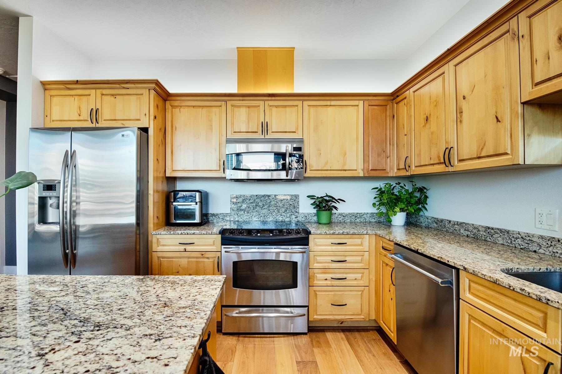 851 West Front Street, Unit 1004 Boise, ID 83702 - Photo 8 of 27 Kitchen with stainless steel appliances, light stone counters, light wood-style flooring, and light brown cabinets