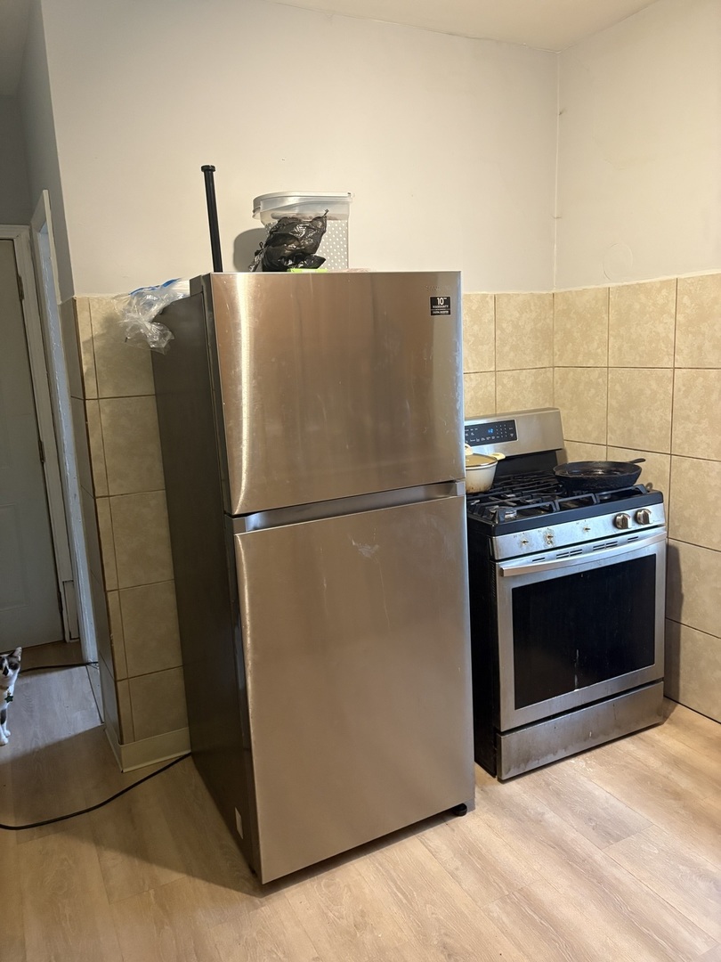 1711 North Austin Avenue Chicago, IL 60639 - Photo 6 of 13 a kitchen with granite countertop a refrigerator and a stove