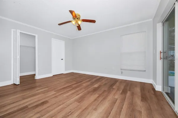 an empty room with wooden floor and natural light