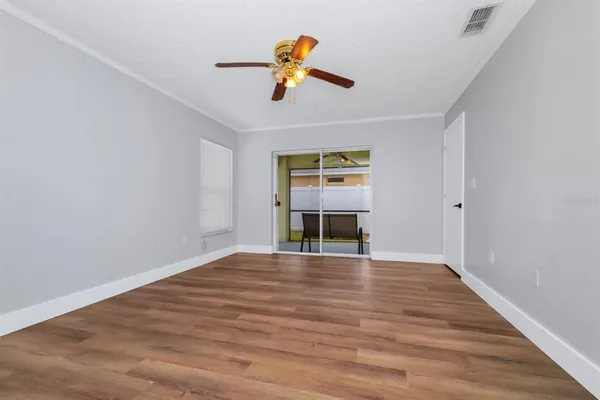 a view of empty room with wooden floor