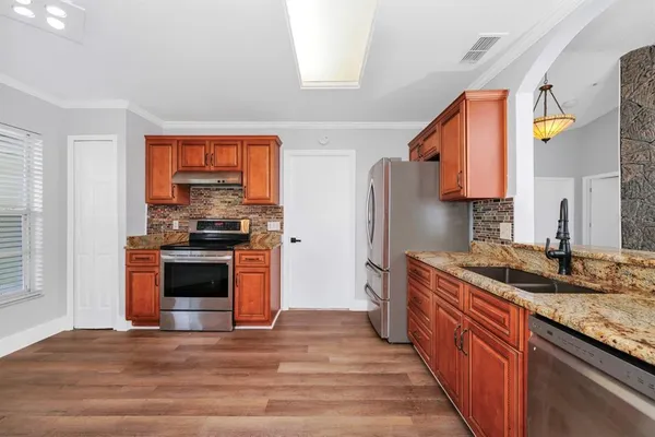 a kitchen with stainless steel appliances granite countertop a stove a sink and a refrigerator